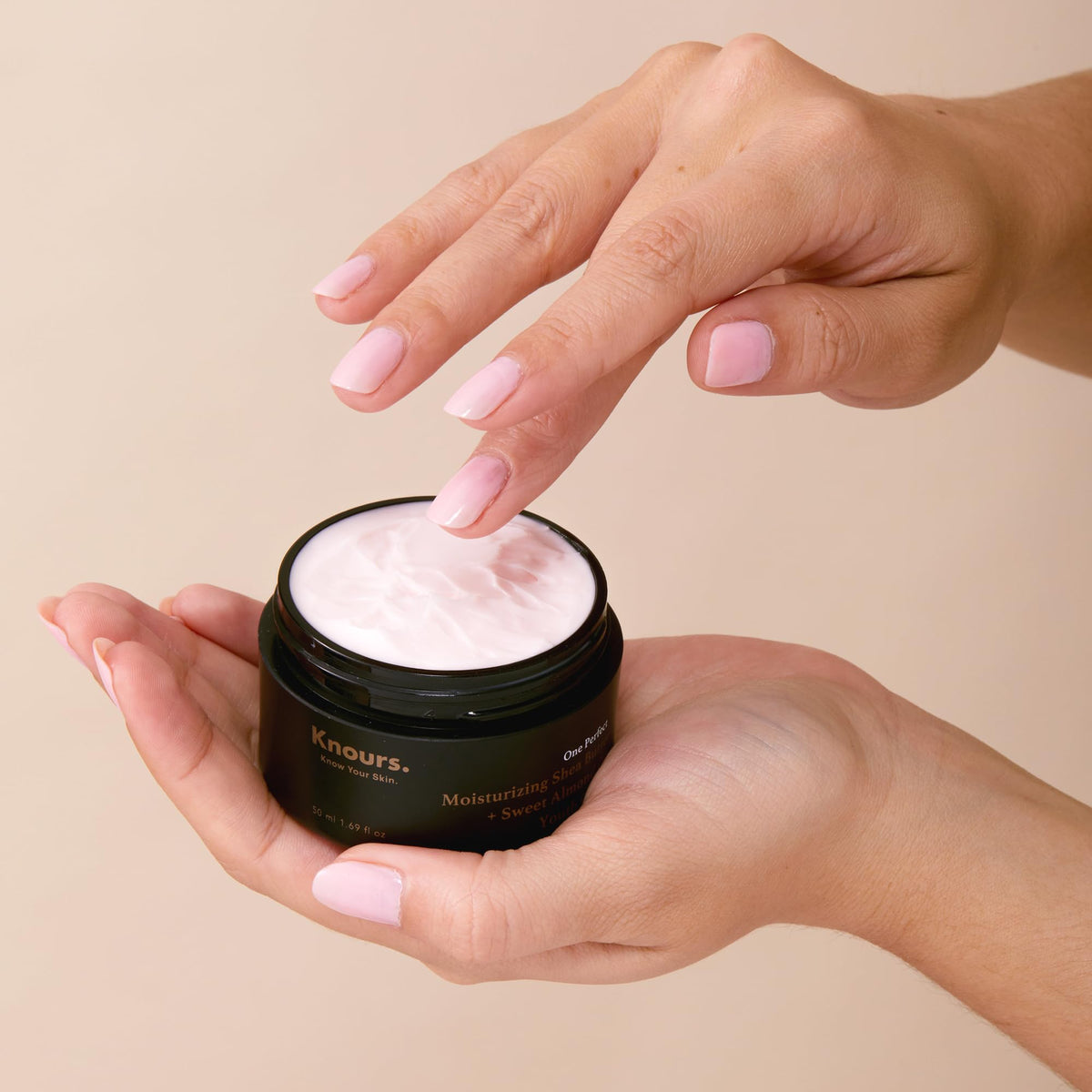 Knours applying cream on hand to show quick absorption and softness