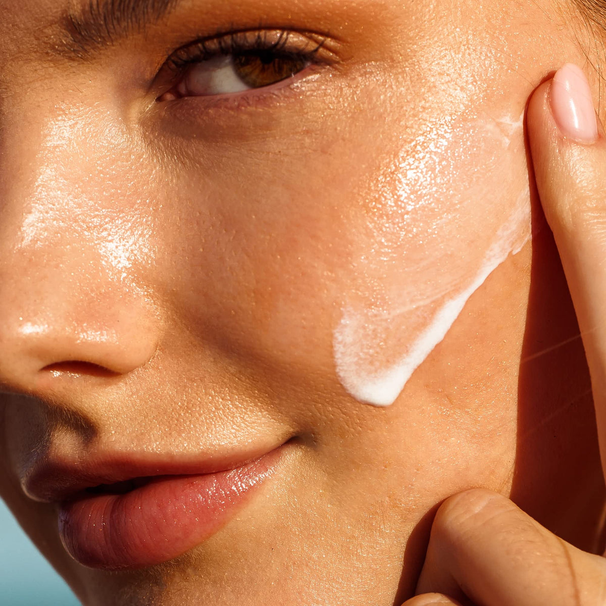 Model applying Kopari in natural light for invisible coverage