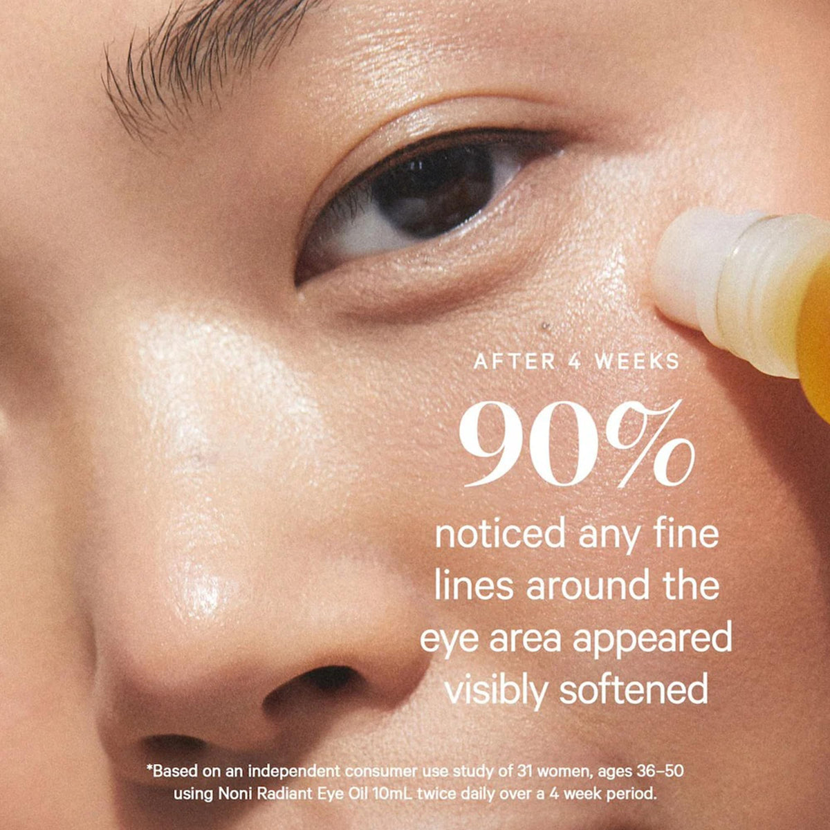 KORA Organics roller in hand applying oil to under-eye for immediate de-puffing benefit