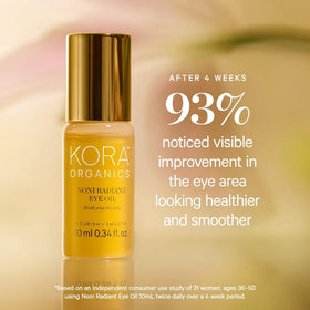 KORA Organics 0.34 fl oz bottle beside fingers to show compact travel-friendly size