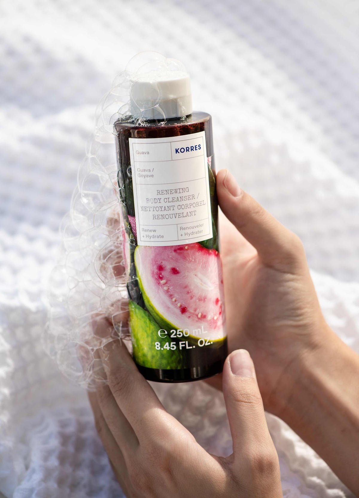 KORRES guava lather and texture on hand, demonstrates creamy foam and hydration
