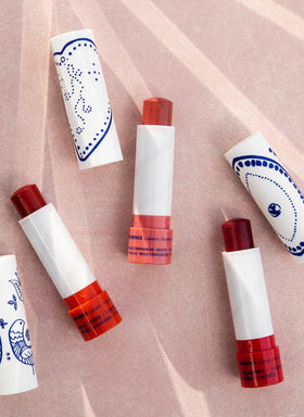 KORRES lip butter in use on lips demonstrating sheer mulberry color