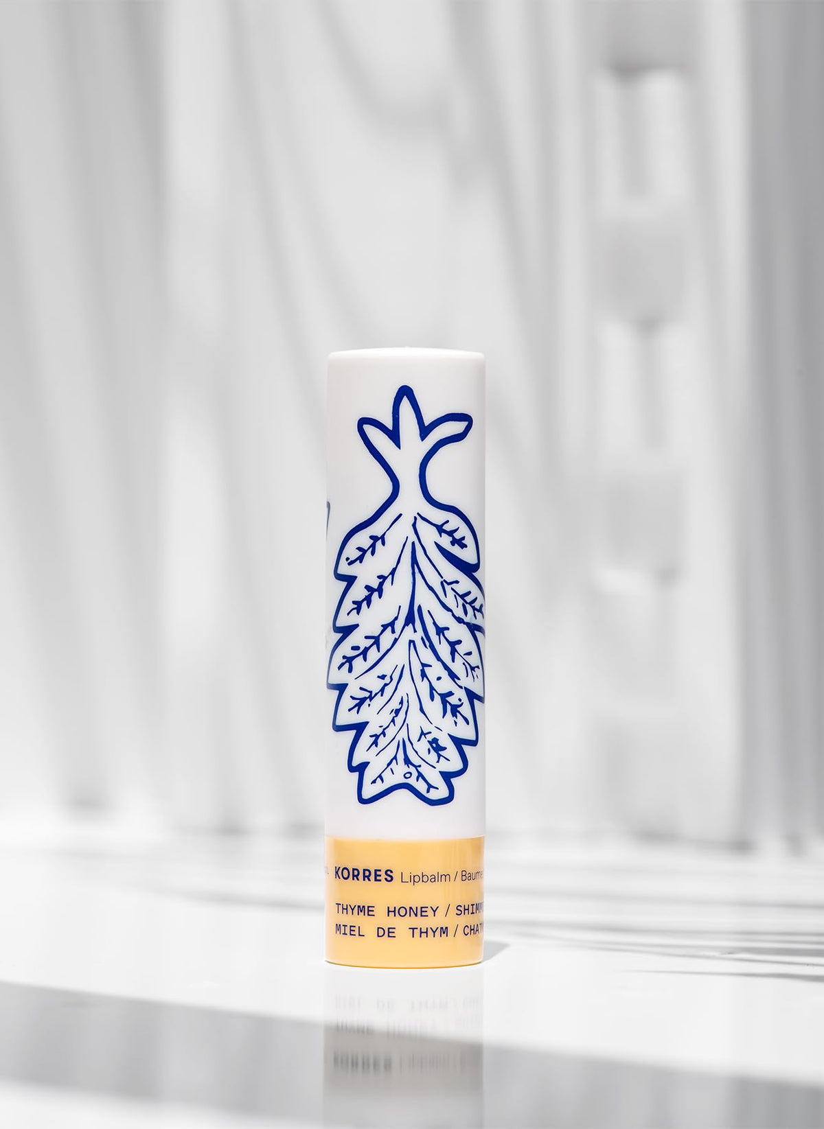 KORRES applied on lips in lifestyle shot, demonstrates subtle golden shimmer