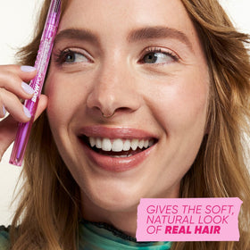 Kosas Brow Pop held in hand to show size and travel-friendly convenience