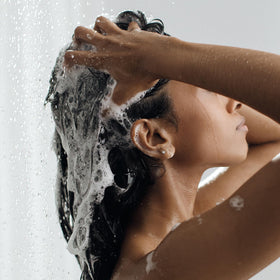 Kristin Ess shampoo being poured demonstrating clarifying cleanse benefit