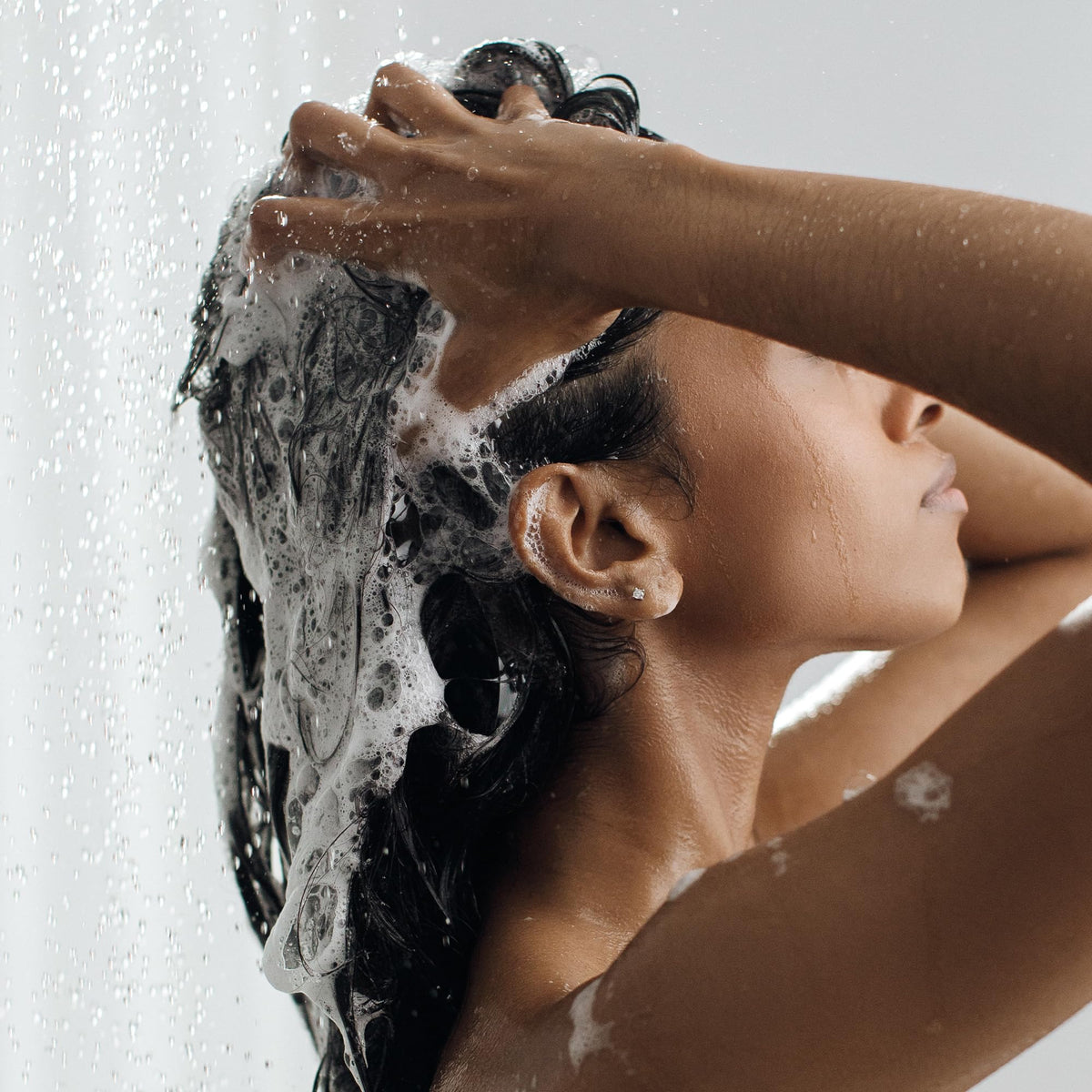 Kristin Ess size comparison in hand showing 33.8oz travel-saving value