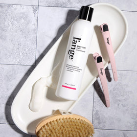 L'ANGE HAIR bottle in hand for scale showing travel-friendly size benefit