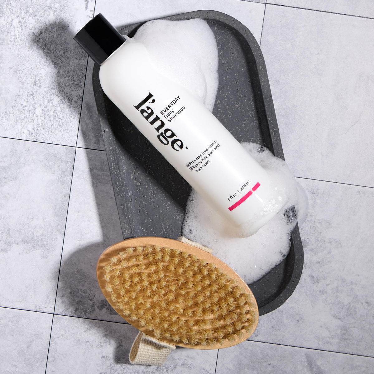 L'ANGE HAIR bottle in shower scene indicating daily routine convenience