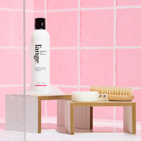 L'ANGE HAIR bottle held in hand to show size and travel-friendly benefit
