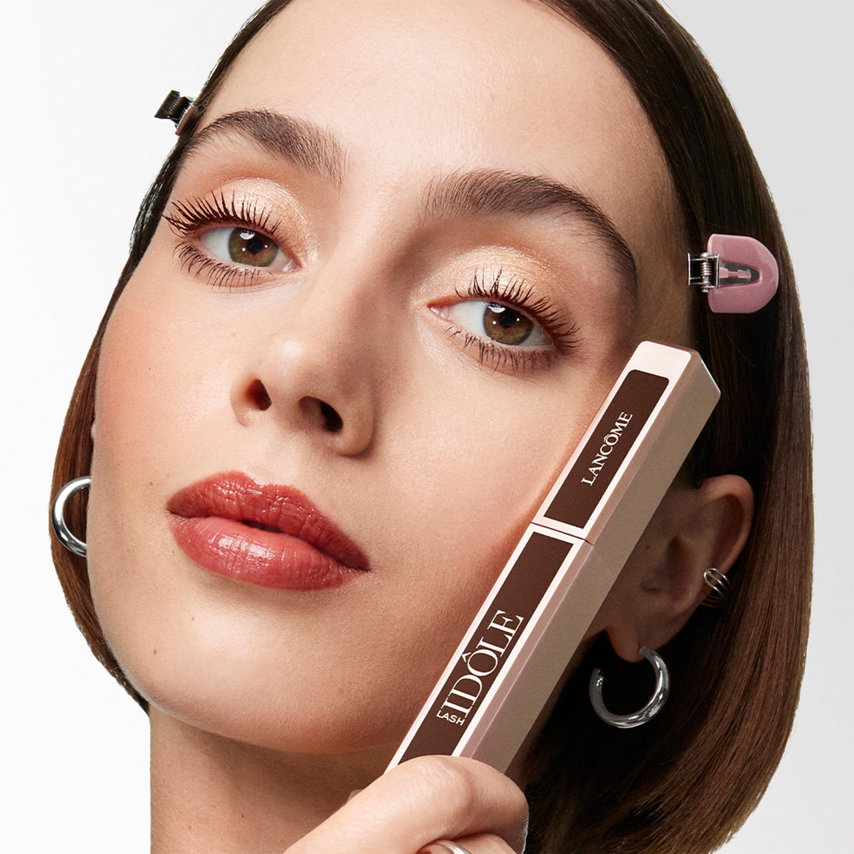 Lancôme Lash Idôle held in hand for scale demonstrating travel-friendly size and portability
