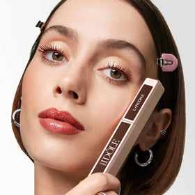 Lancôme Lash Idôle held in hand for scale demonstrating travel-friendly size and portability