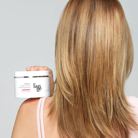 L'ANGE HAIR jar in hand showing 10 oz size for accurate scale