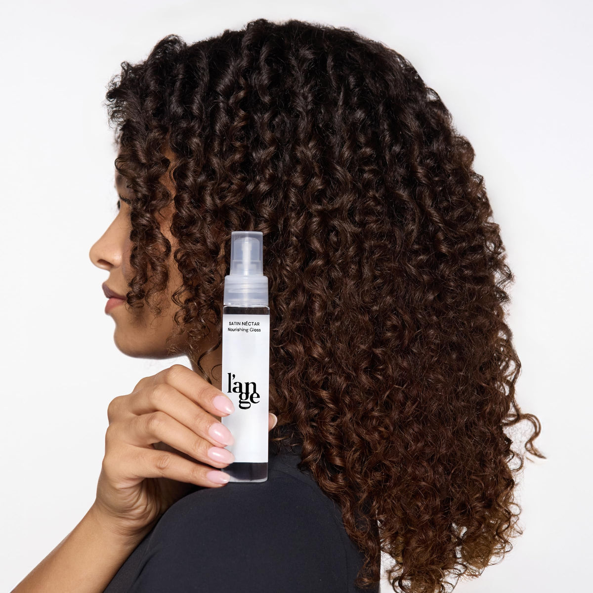 L'ANGE HAIR applying serum to dry hair for instant frizz control and shine