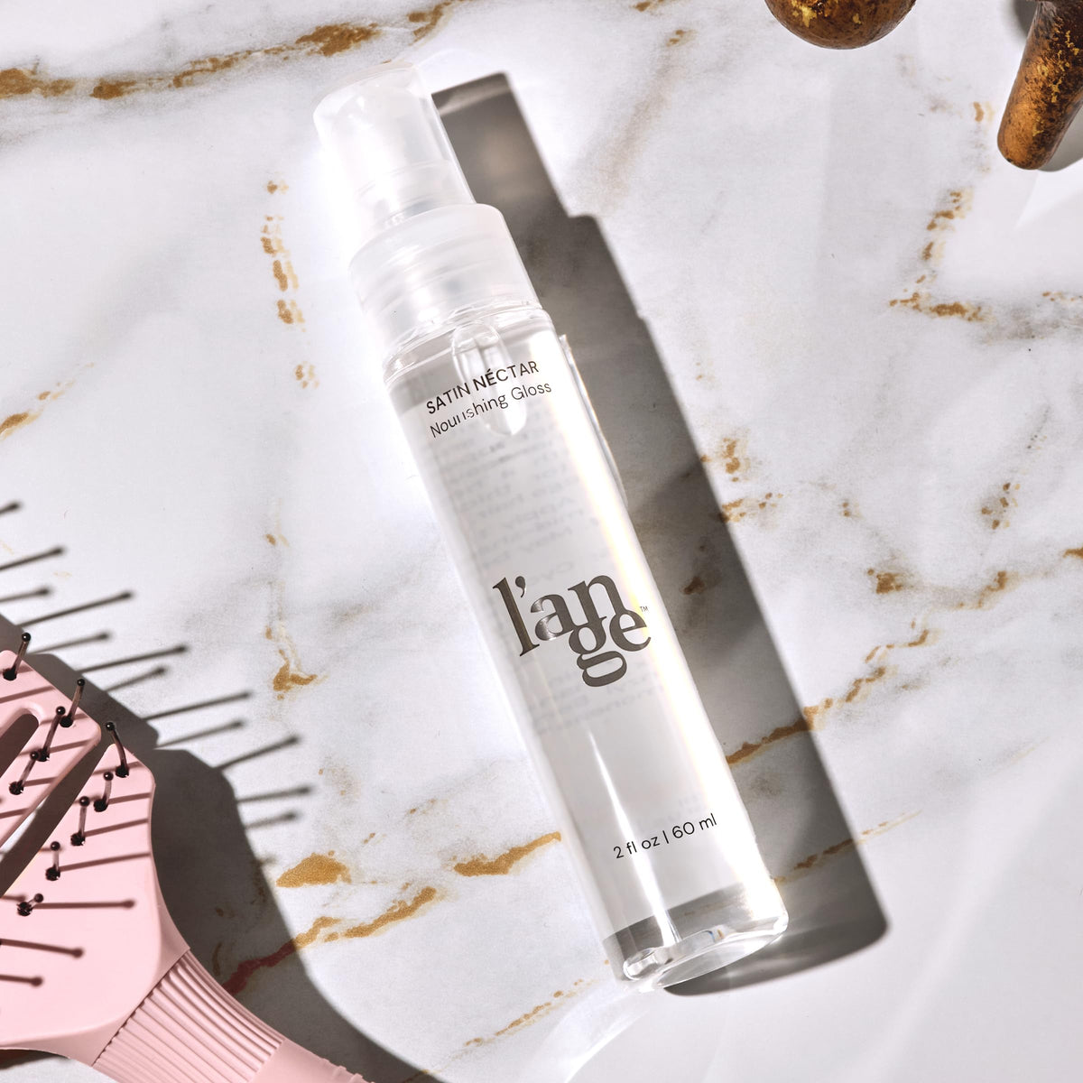 L'ANGE HAIR bottle next to passport showing travel-ready convenience
