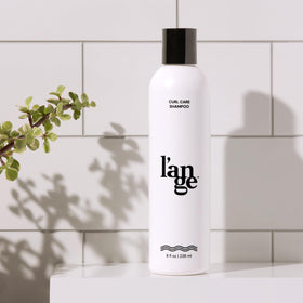 L'ANGE HAIR shampoo on bathroom shelf showing styling routine convenience