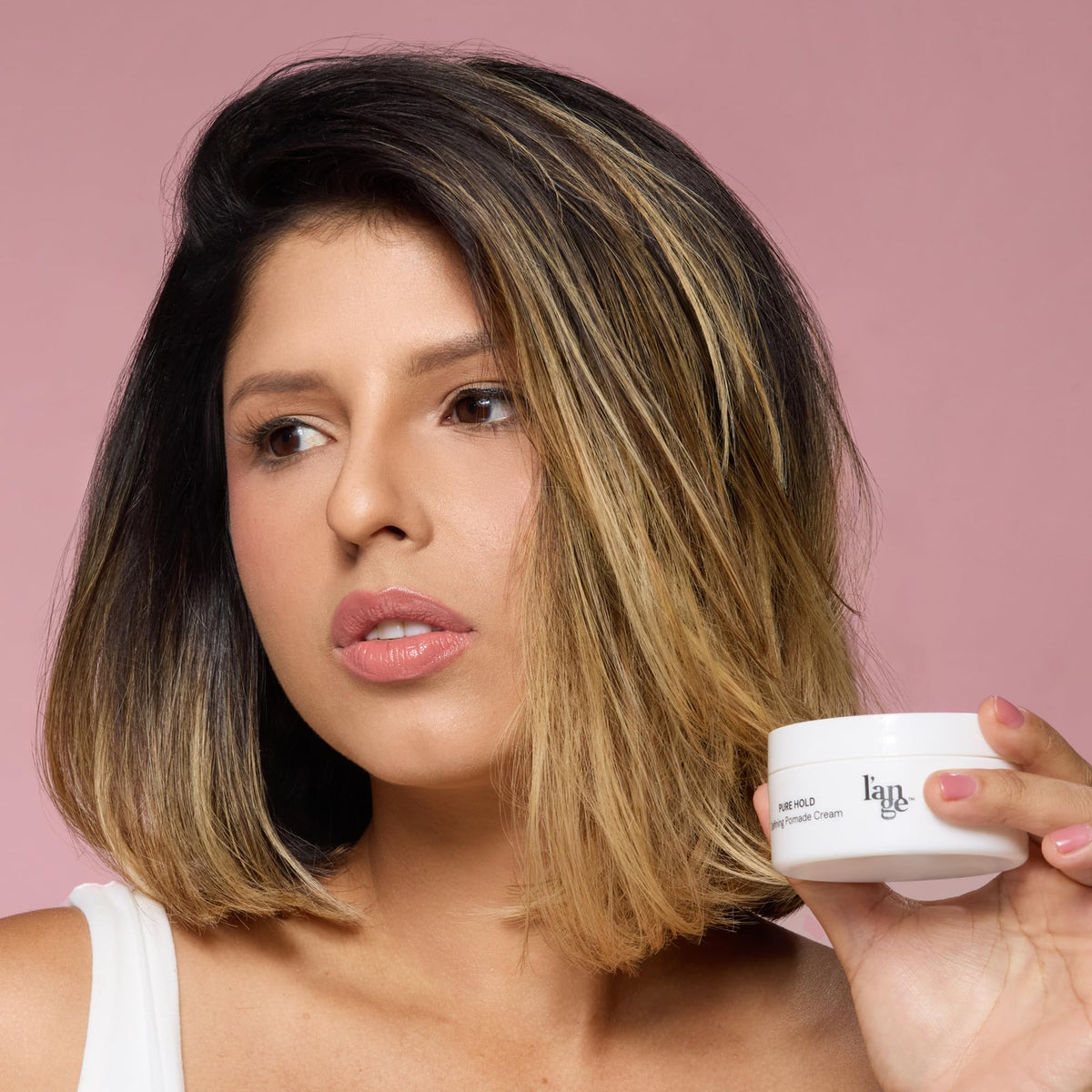 L'ANGE HAIR jar in hand to show portable size and travel convenience