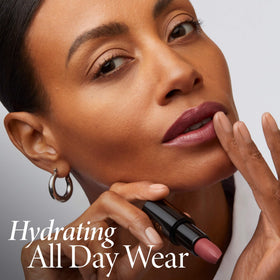 LAURA GELLER NEW YORK lipstick held in hand showing size and portability for on-the-go use