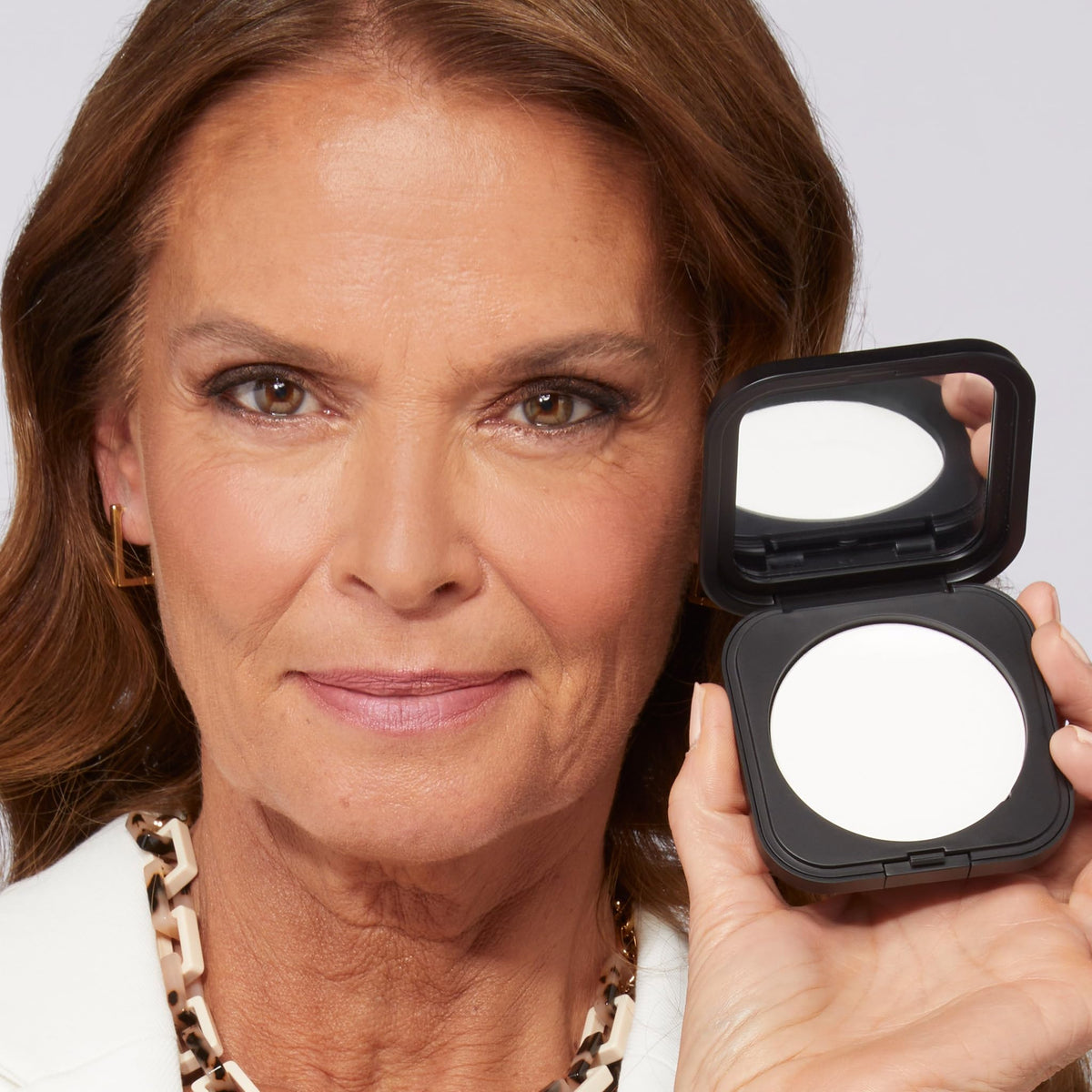 Laura Geller pressed powder texture detail showing fine-milled surface for even application