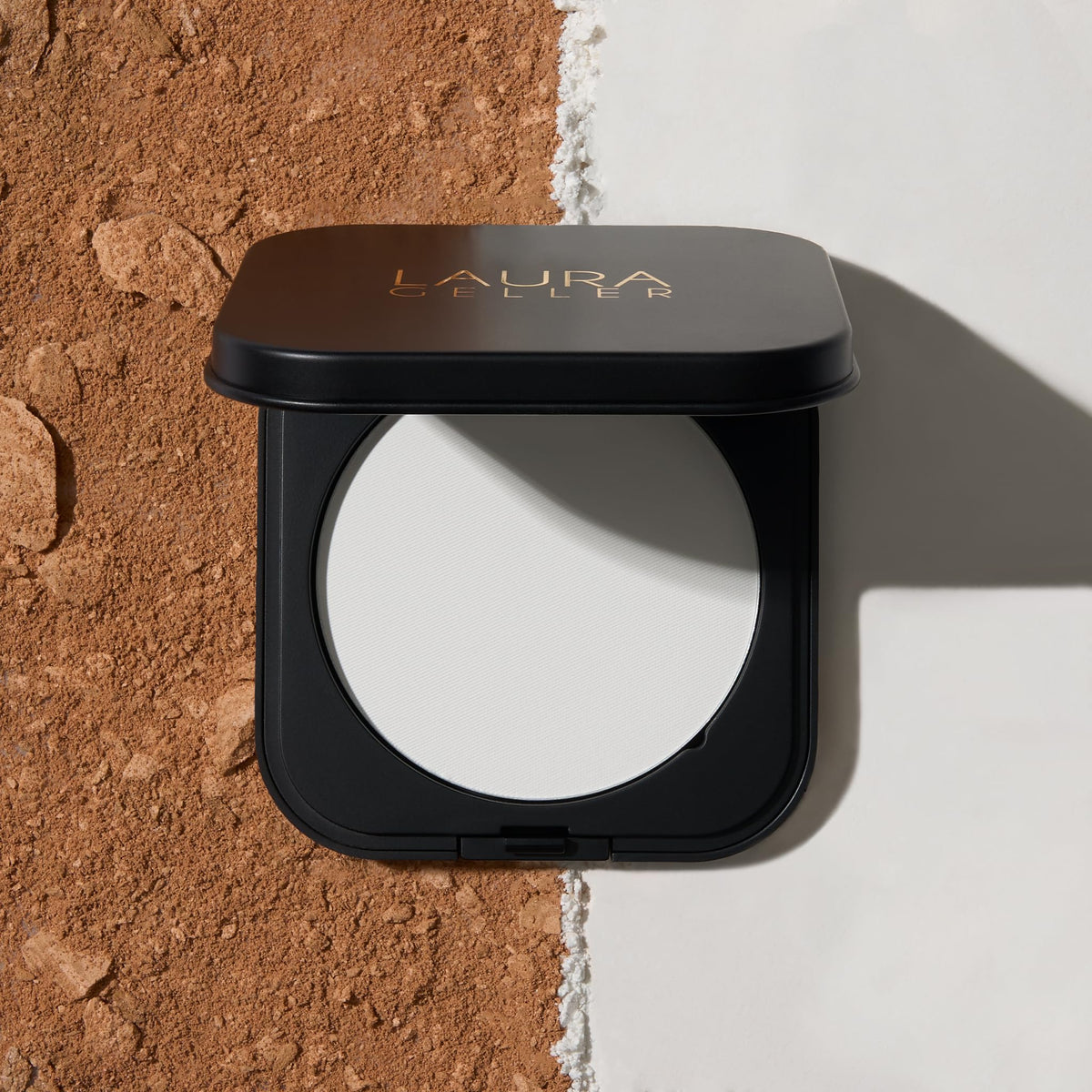 Laura Geller powder puff used for touchup offering precise shine control
