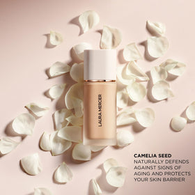 Laura Mercier bottle beside hand for size comparison and travel-friendly benefit