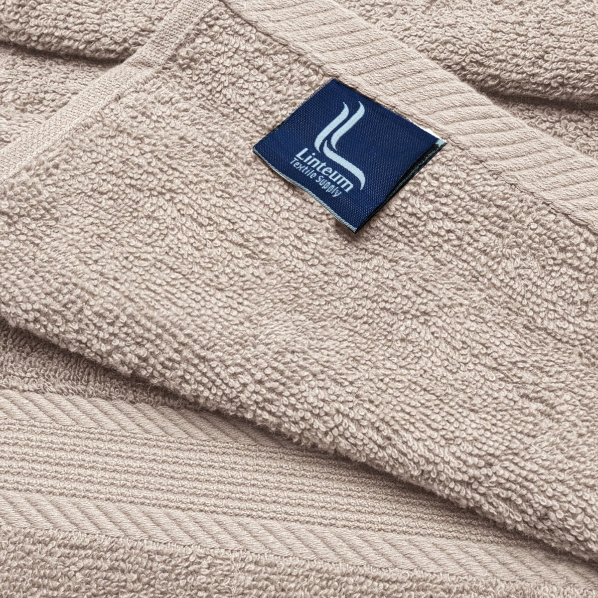 Linteum Textile Supply towel held in hands showing 20x40 inch size for ease