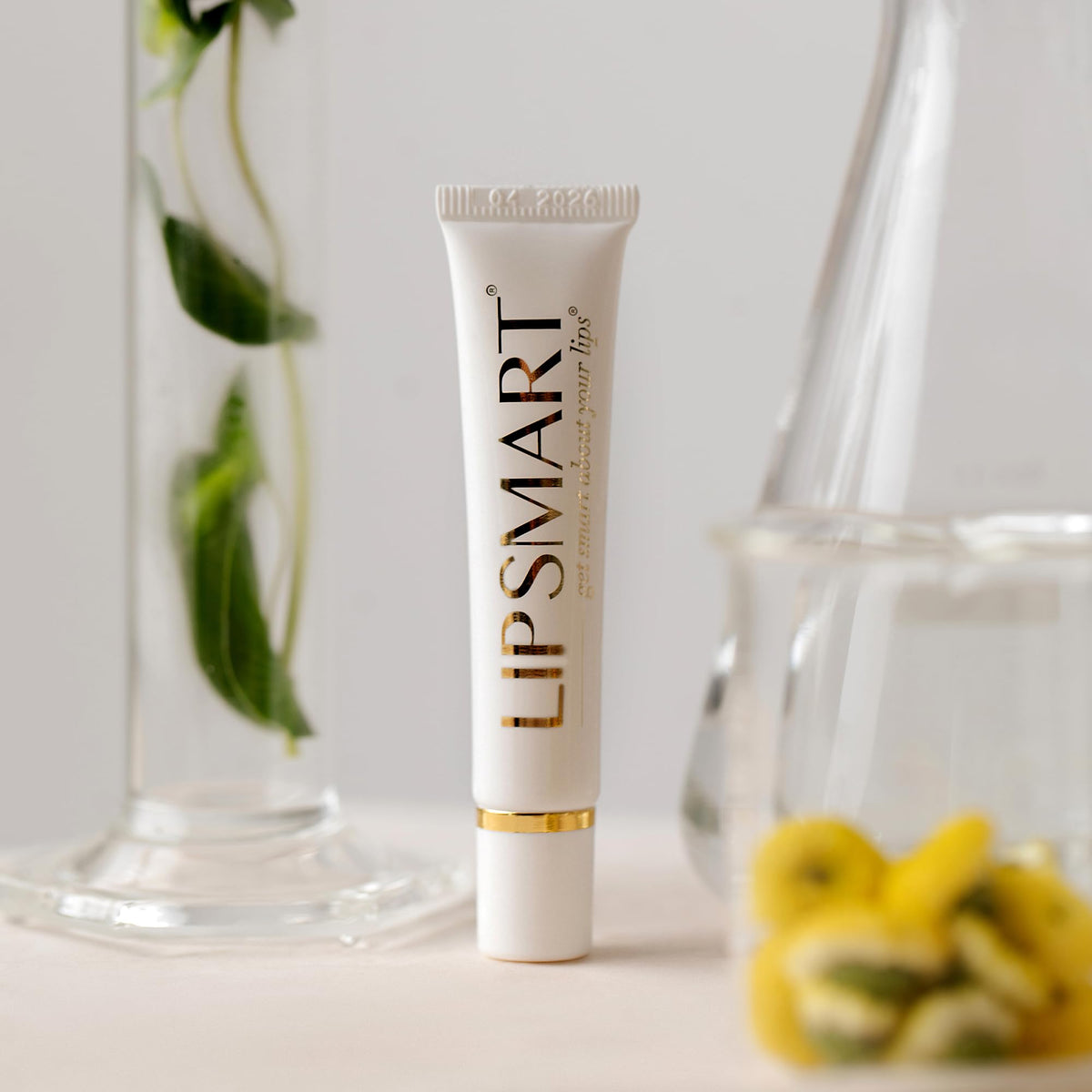 LipSmart next to a coin showing compact travel-friendly product size
