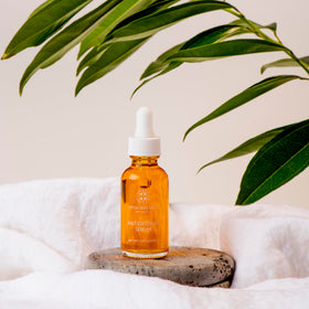 Little Seed Farm serum held in hand to show 1 fl oz size and travel-friendly scale