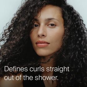 Living Proof applying conditioner into wet hair demonstrating smooth distribution