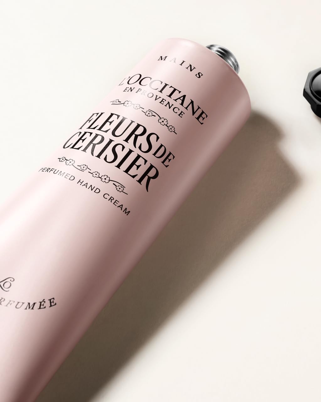 L'OCCITANE tube open with cream being dispensed showing easy use and controlled application