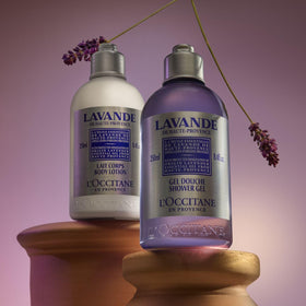 L'OCCITANE bottle next to everyday items illustrating 8.4 fl oz travel-friendly size