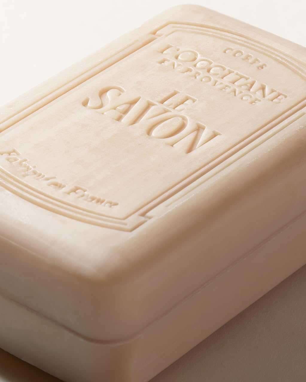 L'OCCITANE soap next to towel for size comparison and long-lasting use benefit