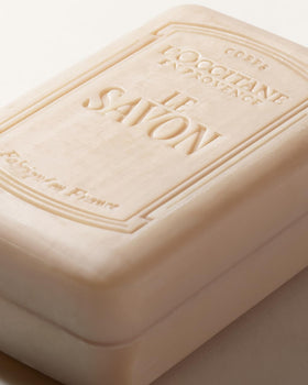 L'OCCITANE soap next to towel for size comparison and long-lasting use benefit