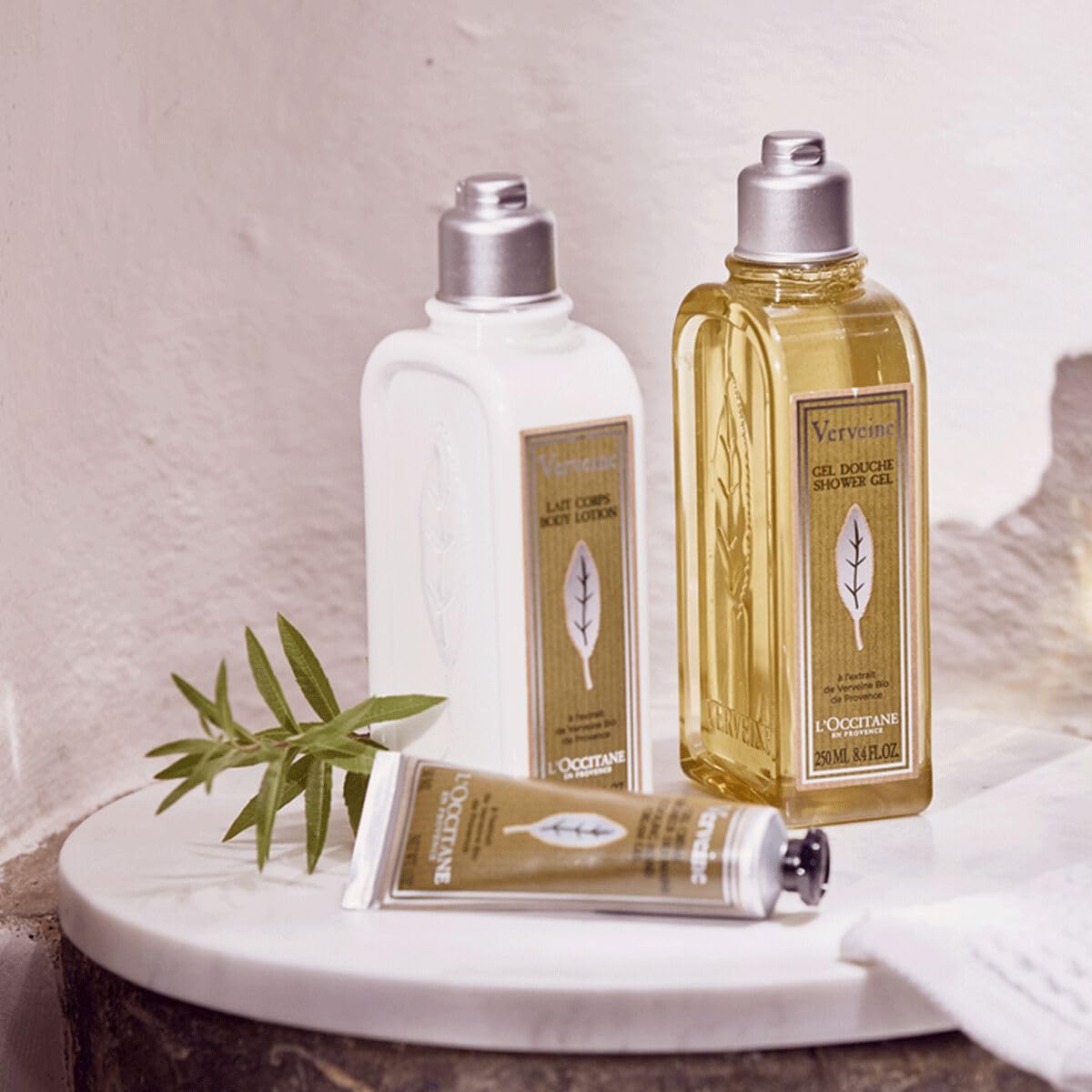 L'OCCITANE size comparison with a hand showing portable 2.6 oz travel-friendly benefit