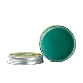 Hand holding Lockhart's 3.4 oz tin for scale to show compact, travel-friendly size