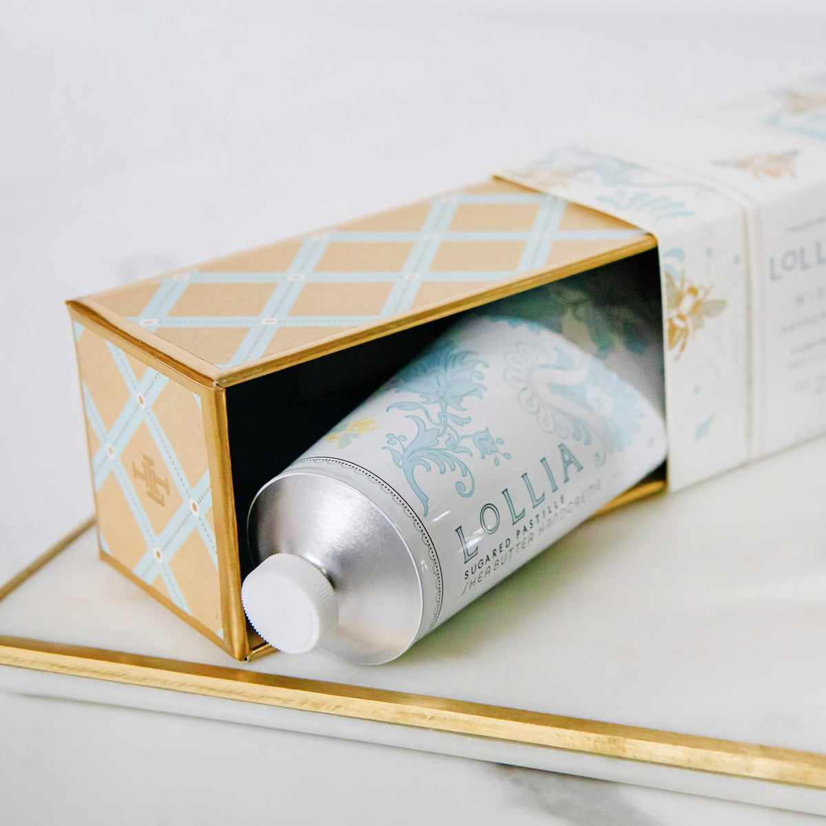 LOLLIA Wish tube next to a hand for scale showing travel-friendly size