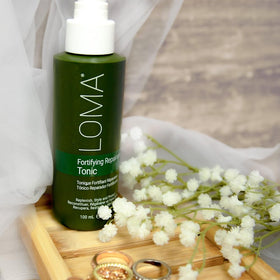 Loma tonic held in hand next to ruler demonstrating 3.4 fl oz travel-friendly size benefit