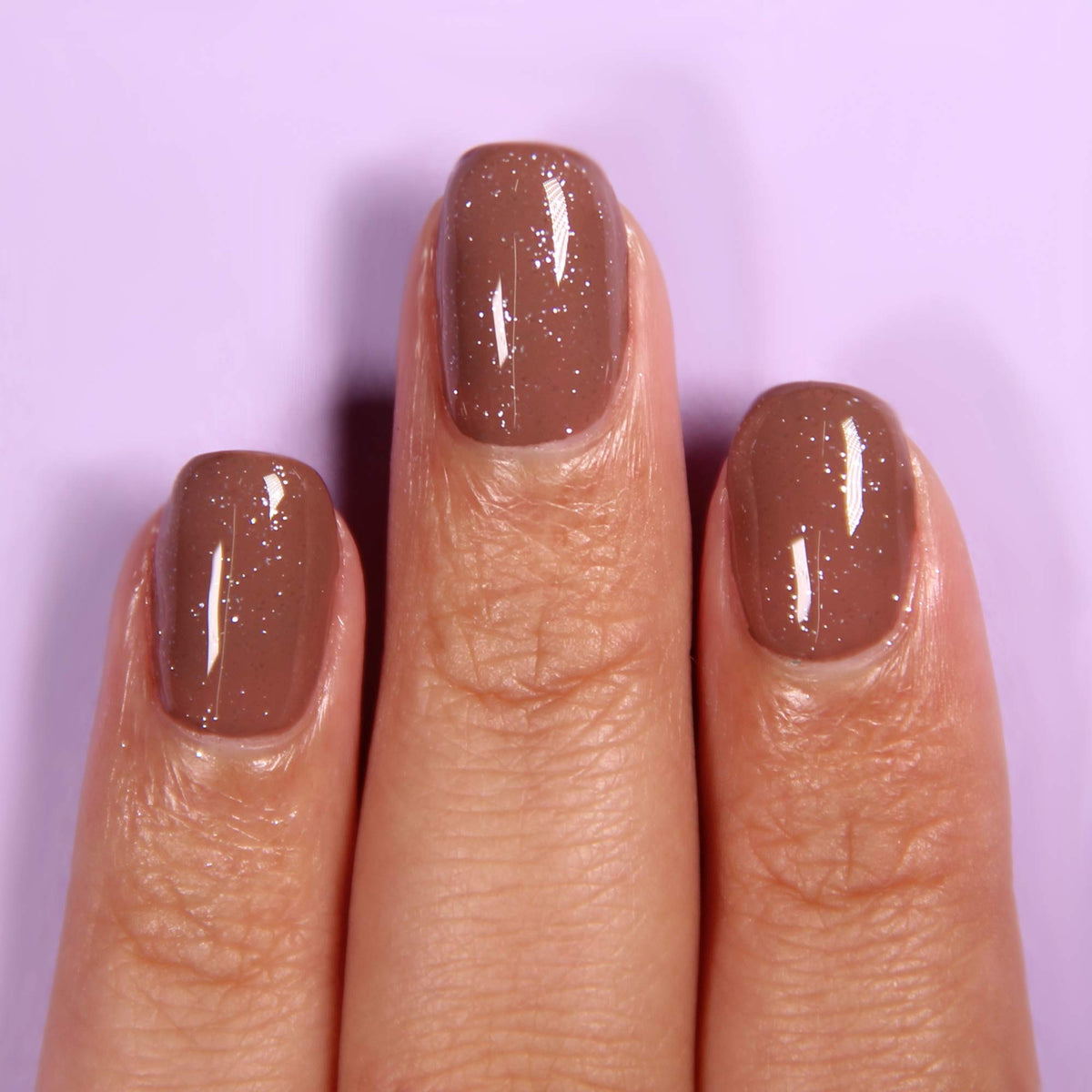 LONDONTOWN kur Top Coat applied on nails in lifestyle scene adding dimension benefit