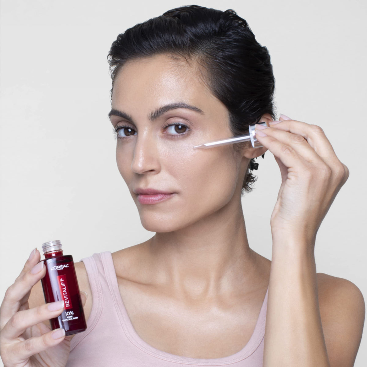 L'Oreal Paris 30ml bottle beside common items showing scale and travel-friendly benefit