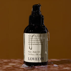 Loved01 bottle next to hand showing 3.4 oz size and portability