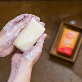 Lume Clean Tangerine bar resting in a draining soap dish to show recommended storage for extended lifespan