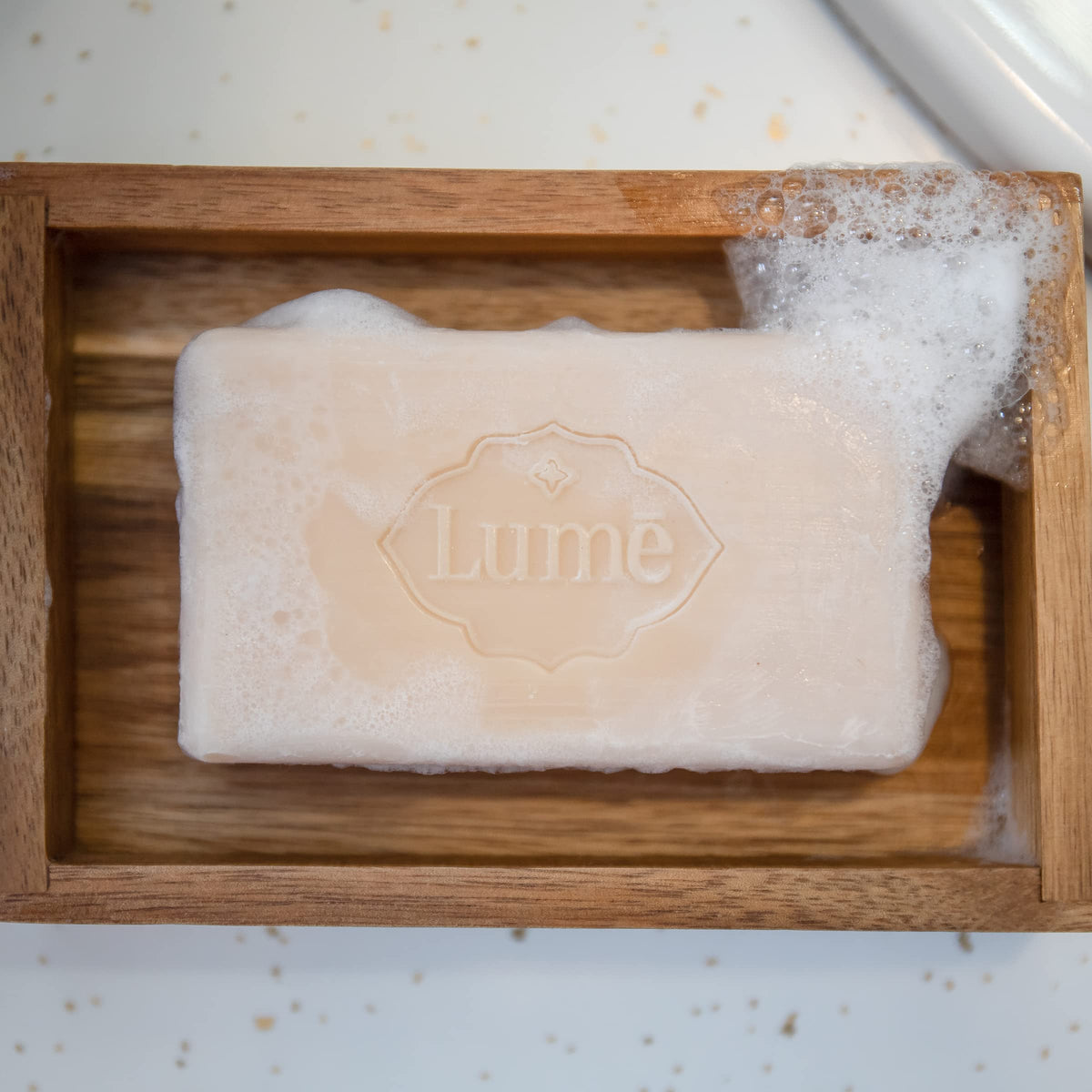 Lume bar being lathered in shower demonstrating gentle cleansing