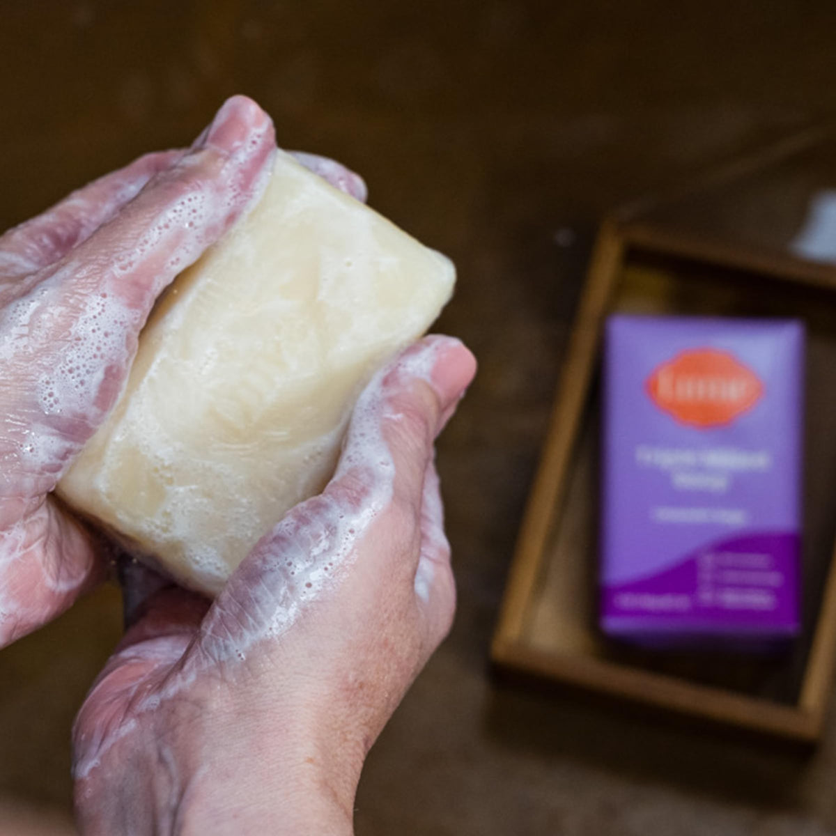 Lume bar soap resting on shower rack to show water resistance and longer life benefit