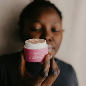 Lumene applying cream to face and neck demonstrating layering under makeup