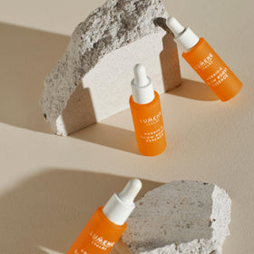 lumene serum placed next to moisturizer in a bathroom scene for layered skincare routine