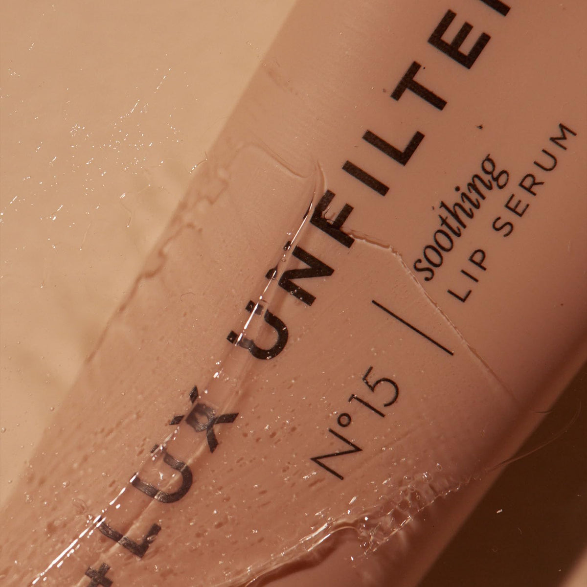 Lux Unfiltered applied on lips in lifestyle scene showing smooth hydrated glossy finish