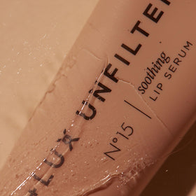 Lux Unfiltered applied on lips in lifestyle scene showing smooth hydrated glossy finish