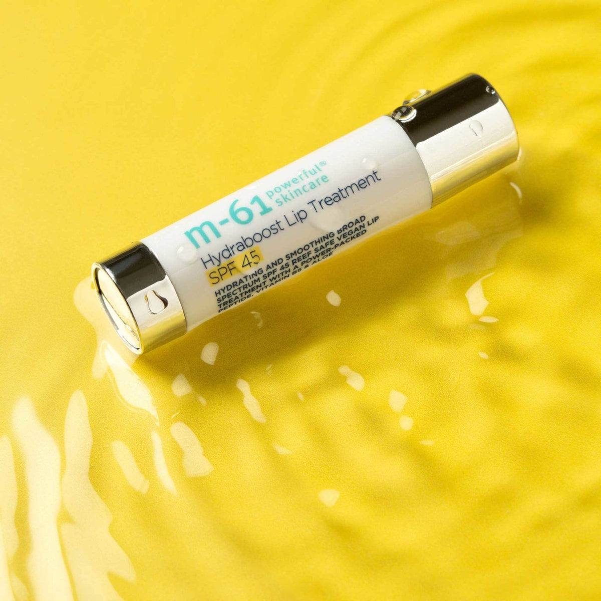 m-61 size comparison in hand showing portable, travel-ready lip treatment