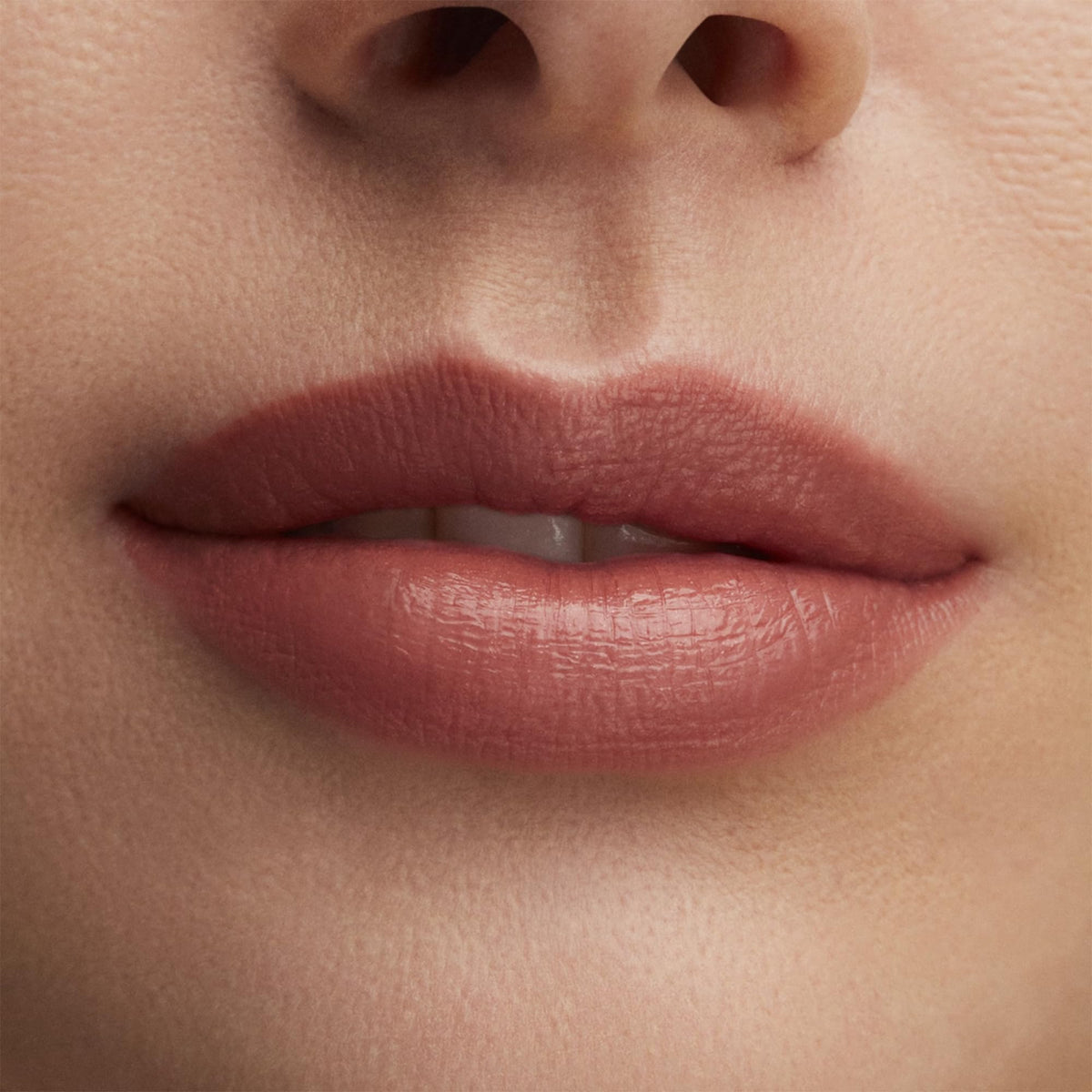 MAC Hug Me swatch on skin illustrating sheer flesh-pink color and wearable nude tone