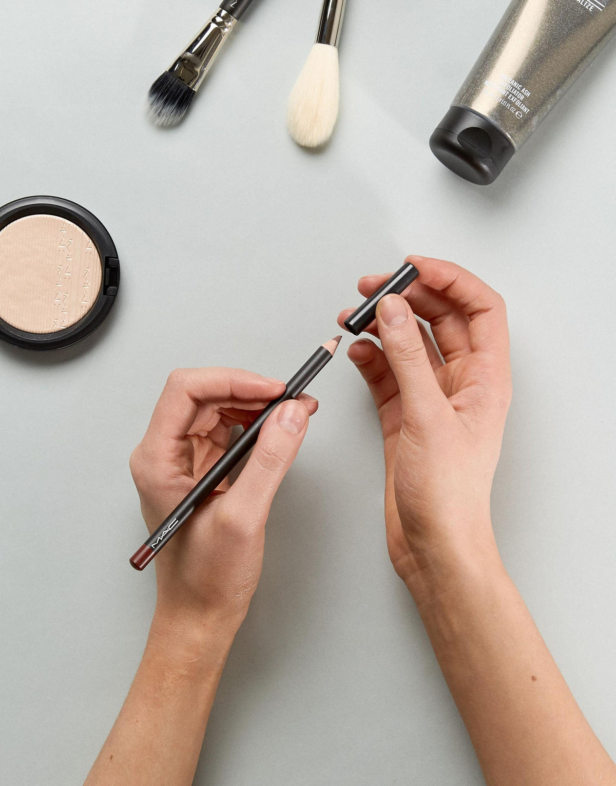 MAC lip pencil Mahogany lifestyle shot with makeup bag for everyday use