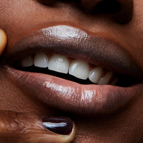 MAC Lipglass next to everyday items showing compact 3.1 ml travel-friendly benefit